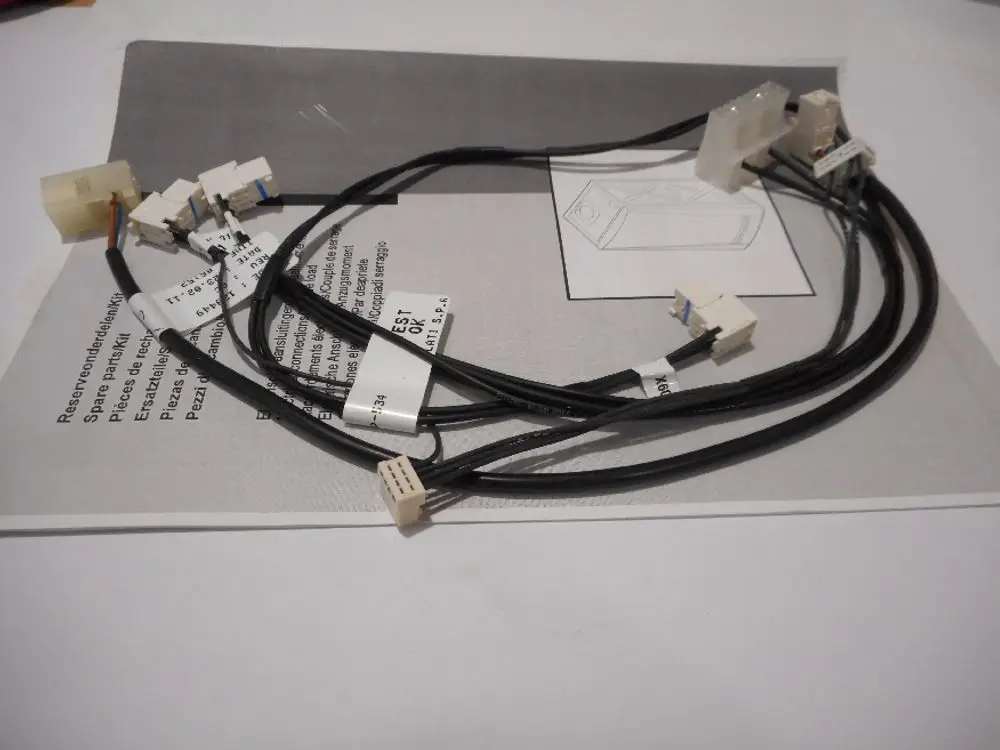 Flachbandkabel mit mehreren Steckverbindern, auf einer Anleitung liegend. Die Beschriftungen weisen auf die Nutzung in Produkten von Remeha hin.
